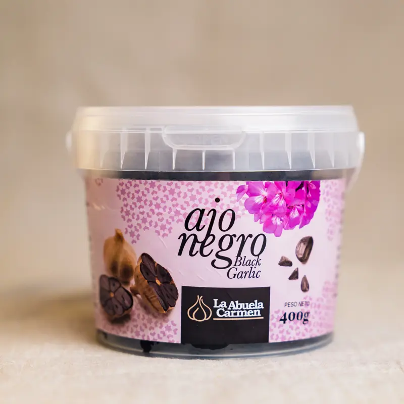 Boks med La Abuela Carmen Sort Hvitløk (400 g) – økologisk fermentert hvitløk med søt, mild smak og umami. Ideell til sauser, kjøtt, grønnsaker og desserter.