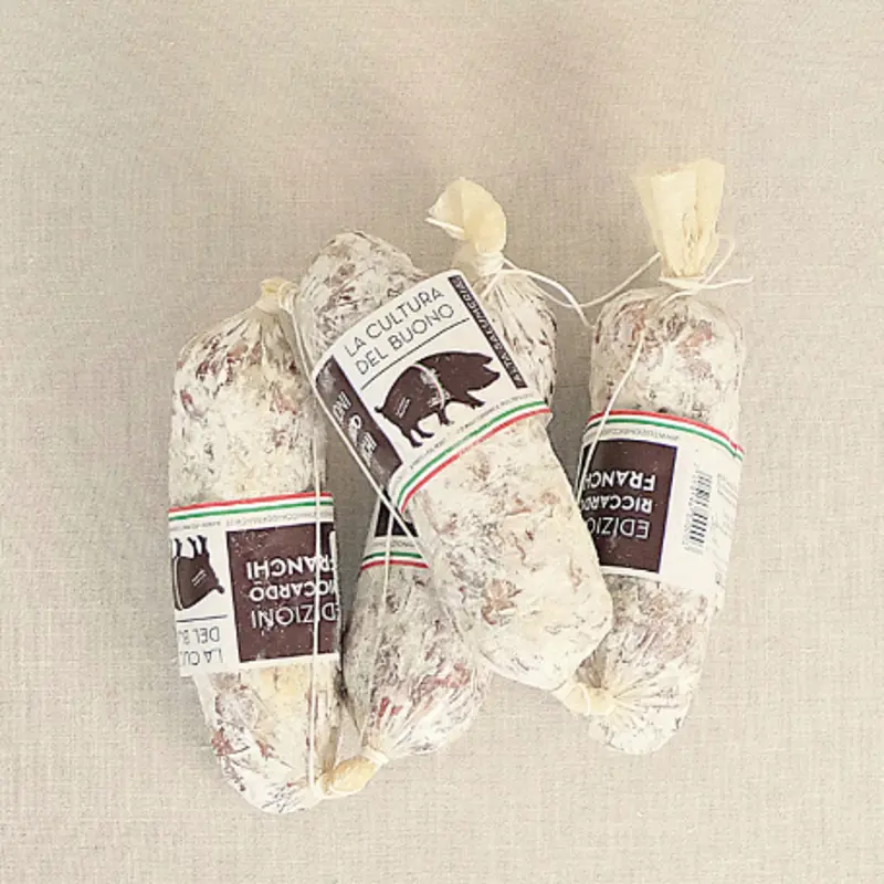 Salametto Finocchietta 180G fra Edizioni Franchi – håndlaget italiensk spekepølse med fennikel, servert på lyst underlag.