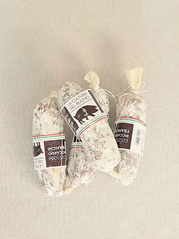 Salametto Finocchietta 180G fra Edizioni Franchi – håndlaget italiensk spekepølse med fennikel, servert på lyst underlag.
