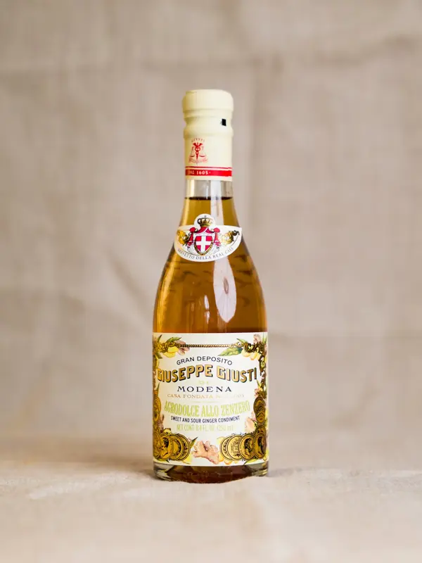 En elegant 250 ml flaske med Agrodolce allo Zenzero fra Giusti – en italiensk gourmeteddik laget av vineddik, druemost og frisk ingefærjuice, kjent for sin balanserte sødme og syrlighet, perfekt til salater, sjømat og cocktails.