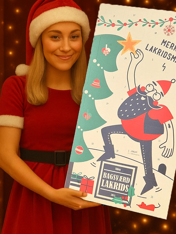 Kvinne i rød julekjole holder Bagsværd Lakrids Julekalender 2025 foran juletrelys – eksklusiv dansk lakris julekalender.